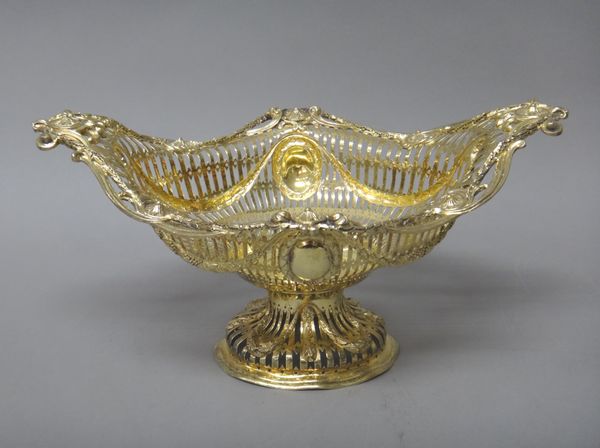 A silver gilt basket, of oval form, cast and pierced with swags and oval cartouches, having wreath shaped surrounds, raised on a similarly decorated o