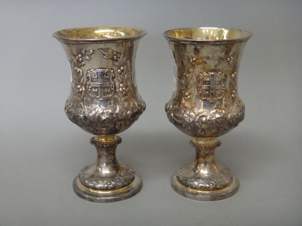 Two similar Victorian silver goblets, each of waisted form, decorated with the shield of Cambridge University within a wreath shaped surround, otherwi