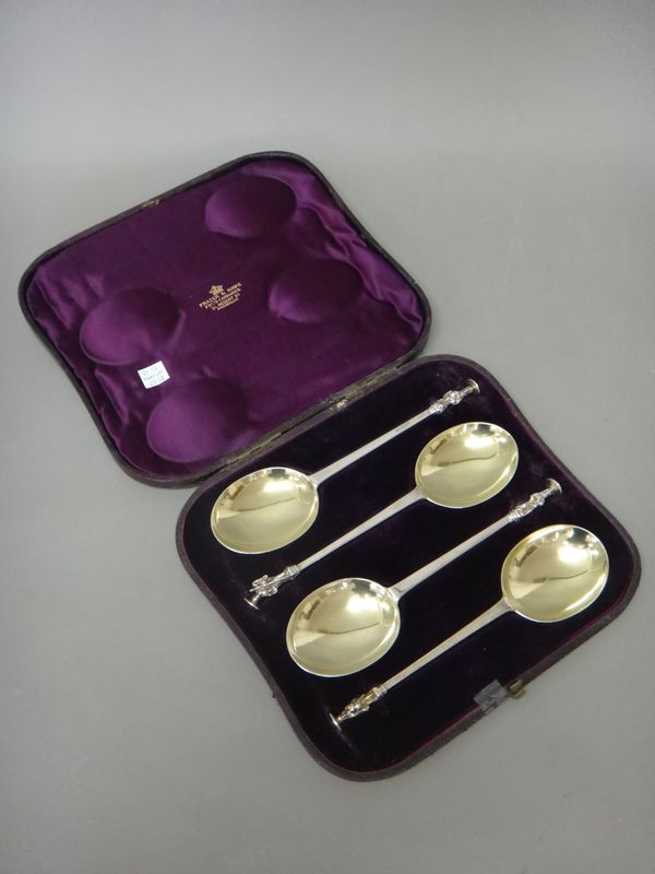 A set of four Victorian silver serving spoons, each with a differing figure terminal, the bowls of the spoons formerly gilt, London 1881, combined wei