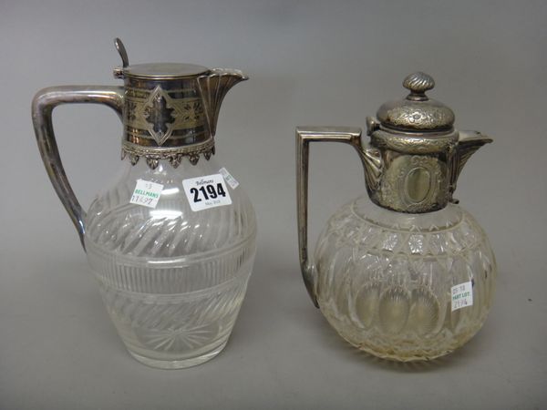 A silver plated metal mounted hinge lidded faceted glass claret jug, having engraved decoration and another silver plated metal mounted hinge lidded f