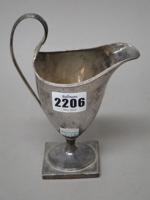 A George III silver milk jug, of helmet shaped form, engraved with floral and foliate swags and raised on a square base, London probably 1809 (also be