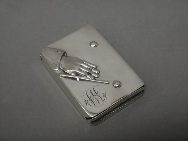 A Victorian silver rectangular hinged vesta case, the cover designed as a hand holding a billiards cue, with two balls, also monogram engraved, Birmin