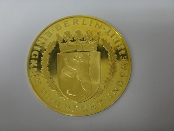 A German gold medallion, detailed to one side Berlin and to the other side with a bell and detailed A New Birth Of Freedom, marked 900, weight 13.8 gm