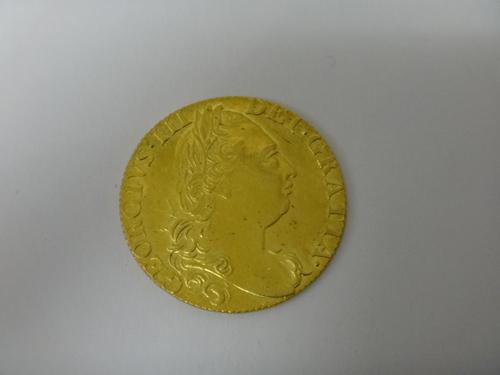 A George III guinea, 4th head 1774, with Spink & Son ticket, detailed Property of Dr Vooglaar.   Illustrated