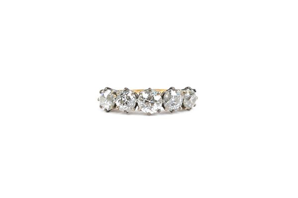 A gold and diamond five stone ring, claw set with a row of cushion shaped diamonds, ring size M, with a case.   Illustrated