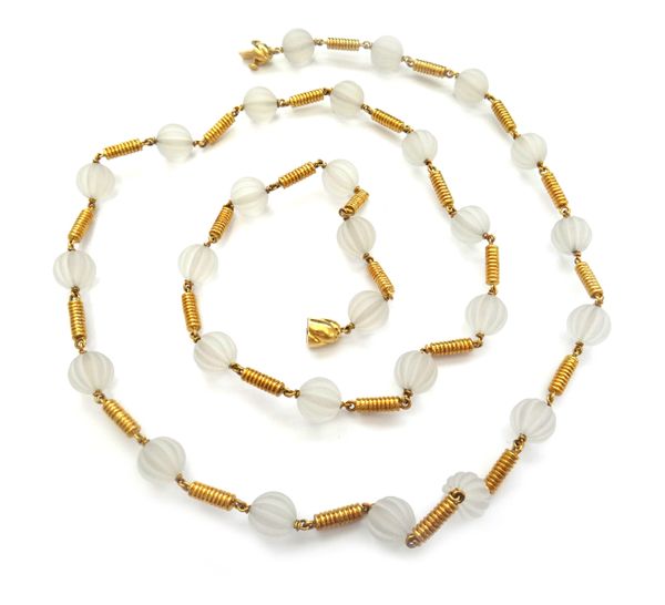 A gold and rock crystal necklace, designed as a single row of melon fluted spherical rock crystal beads, with ridged baton shaped links at intervals,