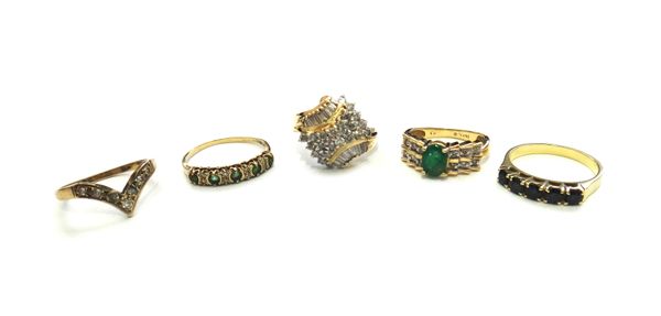 A gold, emerald and diamond ring, claw set with the oval cut emerald to the centre, the sides set with two rows of three circular cut diamonds, detail