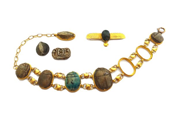 A gold and faience scarab link bracelet, formed as a row of seven scarabs (two detached, but present) and with a further faience drop and a gold mount