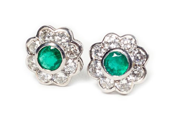 A pair of 18ct white gold, emerald and diamond nine stone cluster earstuds, each mounted with the circular cut emerald at the centre, in a surround of