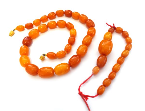 A single row necklace of vary coloured, butterscotch coloured amber beads and another row of vary coloured, butterscotch coloured amber beads, (both i