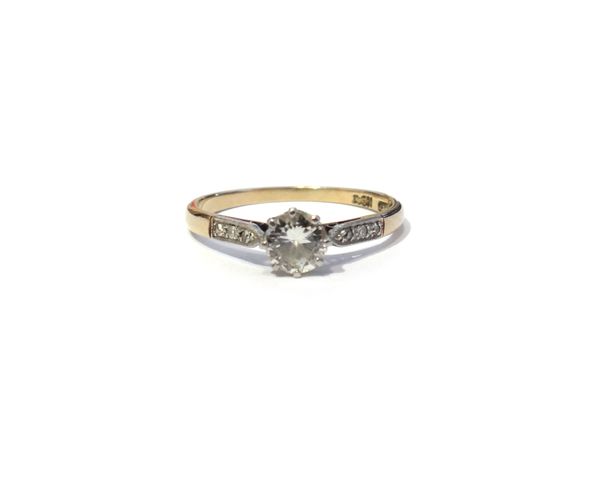 A gold and platinum, diamond set ring, claw set with the principal circular cut diamond between diamond three stone shoulders, detailed PLAT 18 CT, ri