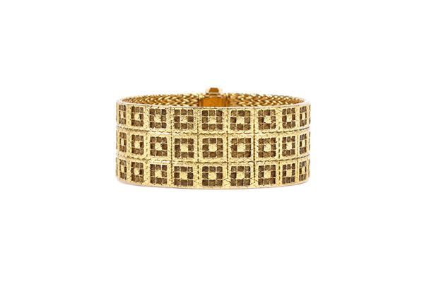 A gold bracelet in a three row wide square design, having a textured finish on a fold over clasp, detailed 750, length 18cm, weight 104 gms, with an a