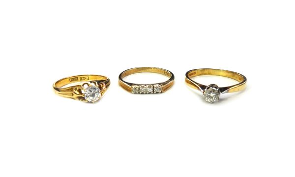 An 18ct gold and diamond single stone ring, claw set with a circular cut diamond, a 9ct gold ring, mounted with a row of four circular cut diamonds an