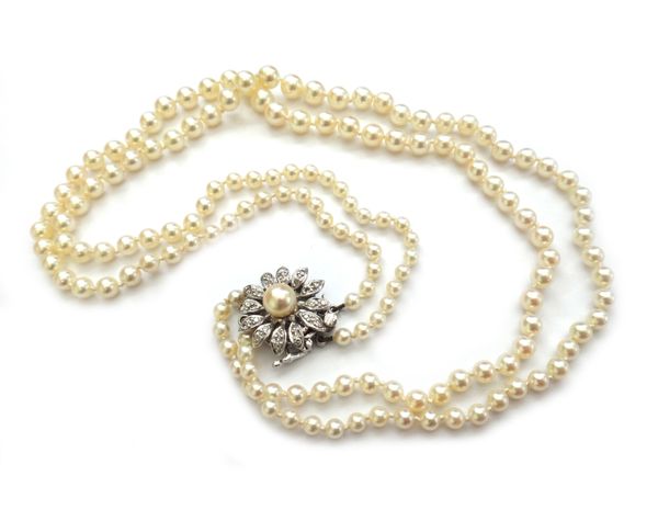 A two row necklace of graduated cultured pearls, on a diamond and cultured pearl clasp, designed as a flowerhead, centred by a single cultured pearl,