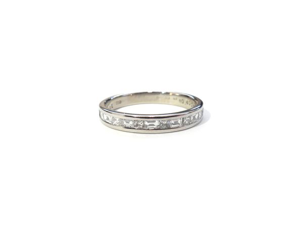 An 18ct white gold and diamond half hoop eternity ring, channel set with alternating baguette and princess cut diamonds, the shank detailed 0.405 CT,