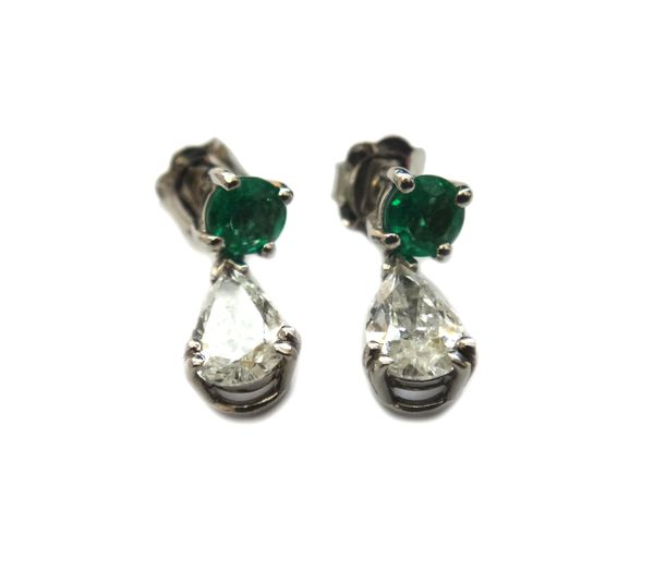 A pair of emerald and diamond two stone pendant earrings, each claw set with a circular cut emerald to the top and with a pear shaped diamond single s