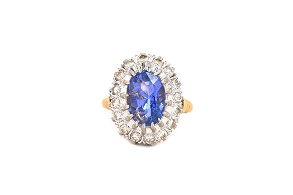 A gold, lavender coloured sapphire and diamond set oval cluster ring, claw set with the oval mixed cut lavender coloured sapphire at the centre, in a