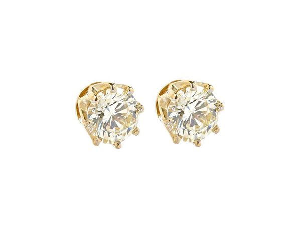 A pair of gold and diamond set single stone earstuds, each claw set with a circular cut diamond, the diamonds weigh approx 1.00 cts each, in a yellow