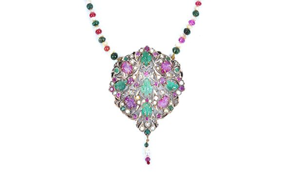 An Indian ruby, emerald, diamond and cultured pearl pendant, with leaf carved rubies and emeralds in a scrolling openwork design, suspending a ruby, e