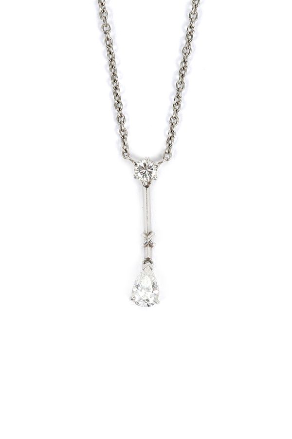 A platinum and diamond two stone pendant necklace, claw set with a circular cut diamond above a pear shaped diamond pendant drop, on a trace link neck