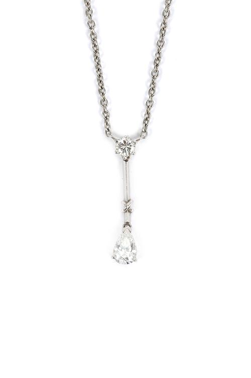 A platinum and diamond two stone pendant necklace, claw set with a circular cut diamond above a pear shaped diamond pendant drop, on a trace link neck