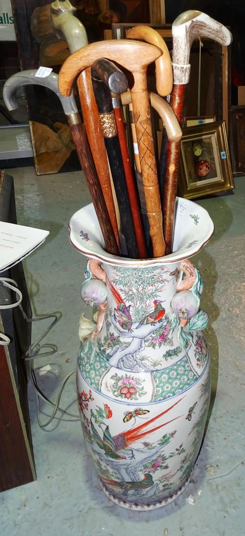 A quantity of 20th century walking sticks, including one with silver handle, contained in a 20th century Chinese vase, (qty).  D1