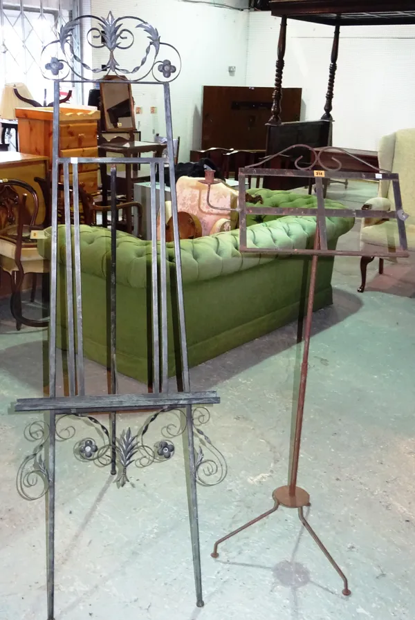 A 20th century wrought iron artist's easel, 59cm wide x 170cm high, an iron reading stand, and a candle holder, (3). E5