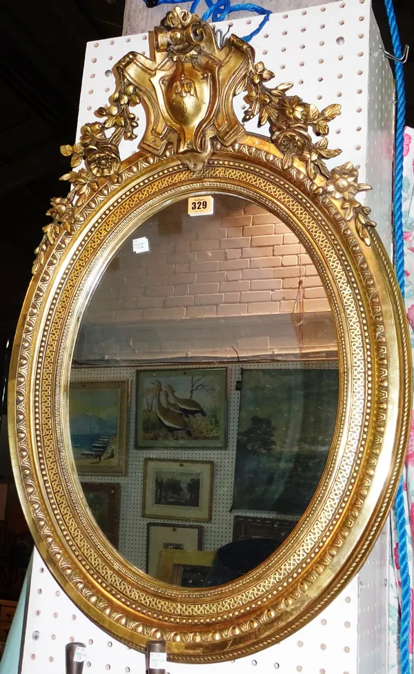 A 20th century gilt framed oval wall mirror with acanthus carved crest, 52cm wide x 76cm high.  D5