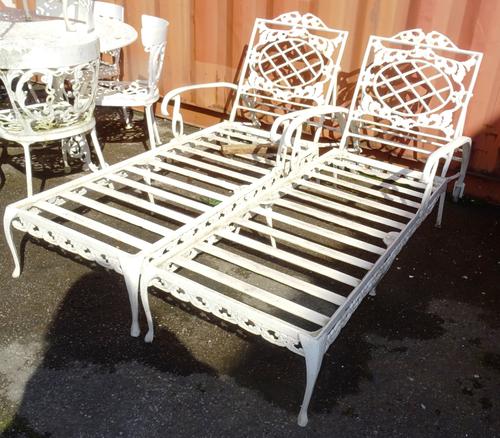 A pair of 20th century white painted metal garden loungers, (2).  OUT