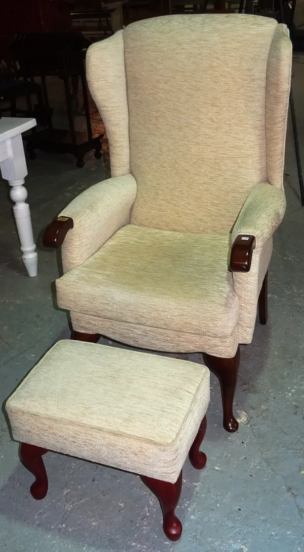 A 20th century oak framed wing back armchair, and a matching footstool, (2).  J5