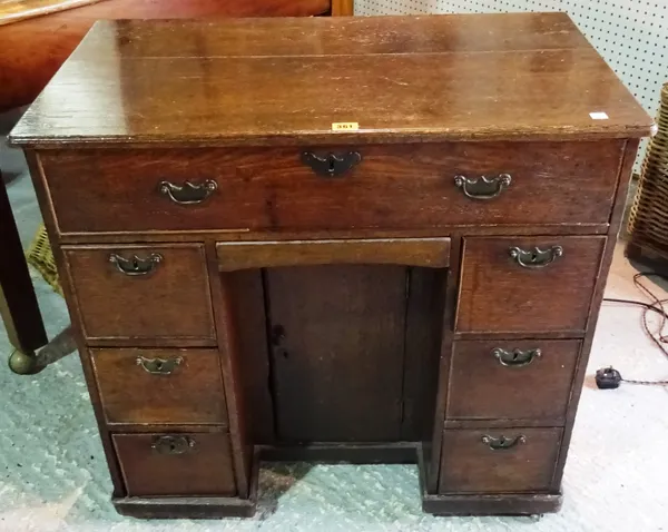 A mid-18th century oak kneehole desk, with seven drawers and cupboard about the knee, 79cm wide x 76cm high.  A9
