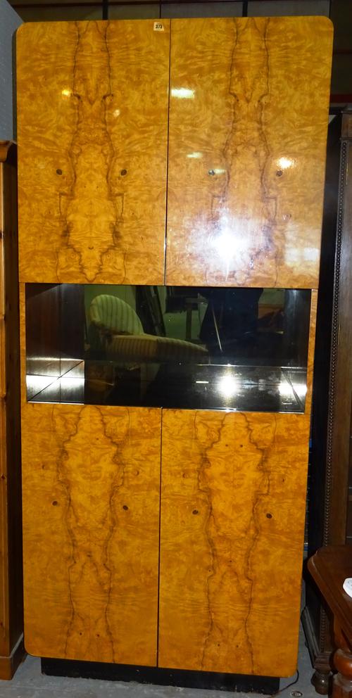 A 20th century satinwood and ebonised drinks cabinet with central mirrored back shelf and two door cupboard above and below, 92cm wide x 215cm high. M