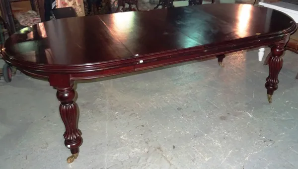 A Victorian style mahogany oval extending dining table, with pair of leaves and winder, on reeded tapering supports, 140cm wide x 75cm high x 240cm fu