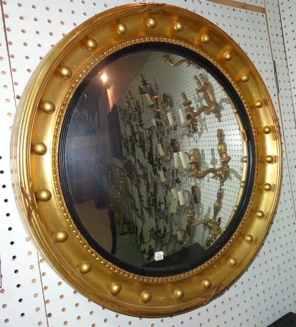 A George IV style gilt and ebonised circular convex mirror, 66cm wide x 66cm high.  G10