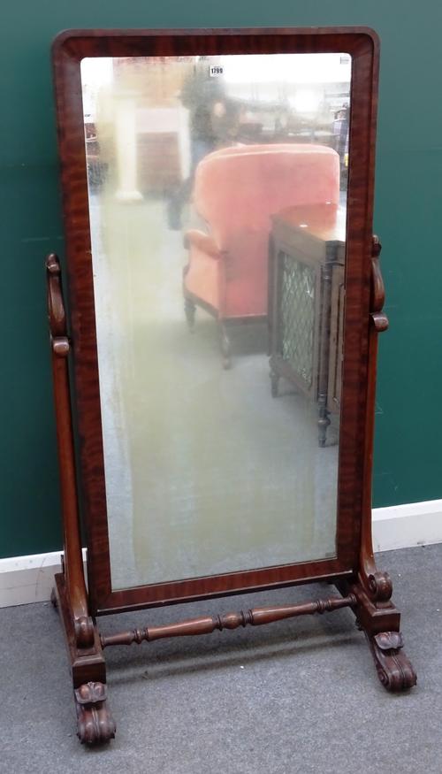 An early Victorian mahogany cheval mirror with stylized tulip carved supports and scroll feet, 80cm wide x 154cm high.  J6