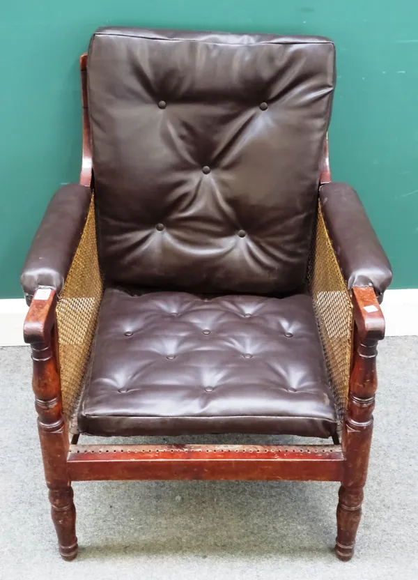 A Victorian mahogany and caned bergère library armchair, later button upholstered back and arms, on turned tapering supports, 66cm wide x 81.5cm high.