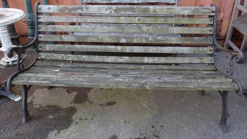 An early 20th century cast iron slatted garden bench with vine decoration, 150cm wide.   OUT