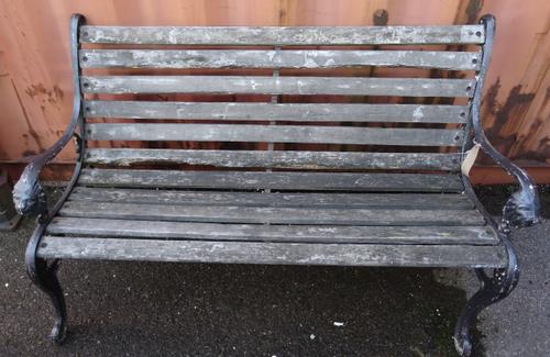 An early 20th century cast iron slatted garden bench with lion mask finials, 127cm wide.  OUT