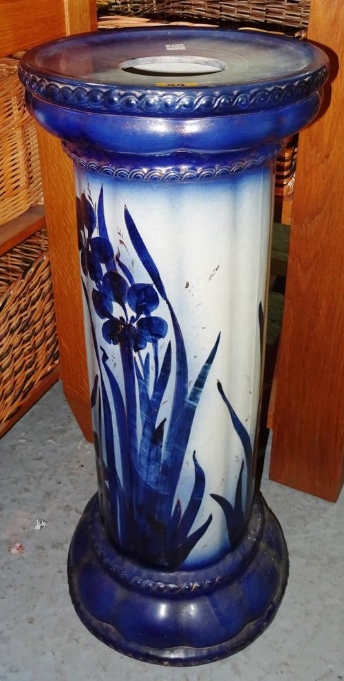 An early 20th century Continental blue and white pottery jardinière stand, with ram's head decoration, and a floral blue and white jardinière, (2).  H