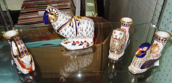 Three Royal Crown Derby Imari candlesticks (lacking gold button), comprising; a winged lion, a winged ram and a griffin, also one further ram paperwei