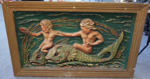 A polychrome painted rectangular panel, early 20th century, relief moulded plaster on pine depicting two putto riding mythological dolphins within a s