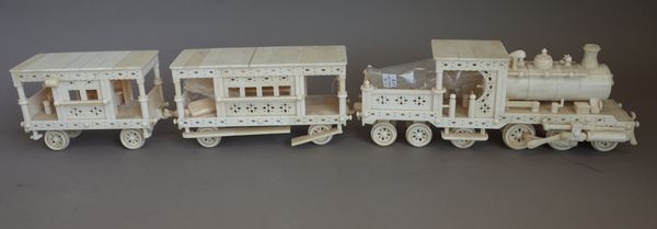 A marine ivory and bone, scale model locomotive and two passenger coaches, C.1900, displayed on a folding track, (a.f) locomotive, 34cm wide, (4).   I