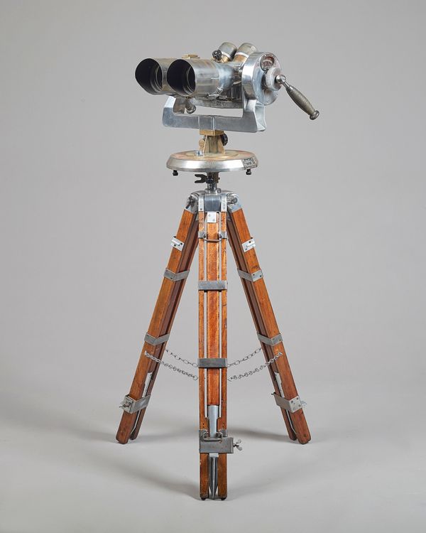 A military binocular, anti-aircraft identification range-finder, alloy and brass on an adjustable tripod base. Illustrated.