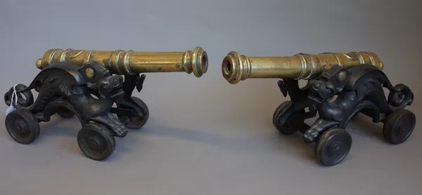 A pair of 18th century style brass cannons, each turned barrel (38cm) with applied roundel and stamped marks mounted on 'dragon' cast iron four wheele