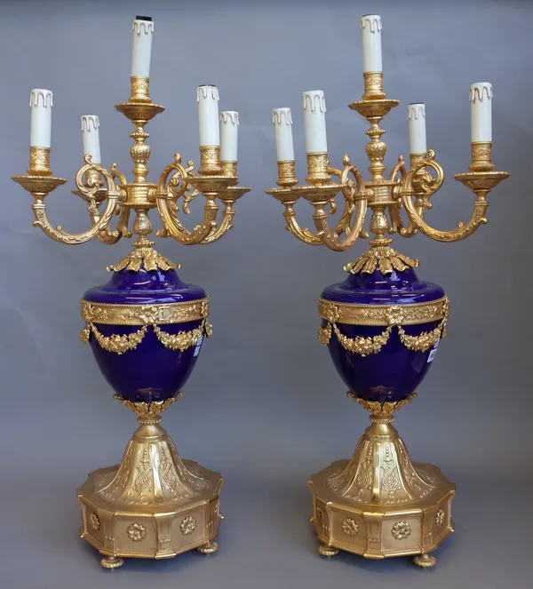 A pair of Louis XVI style porcelain and gilt metal mounted five branch candelabra, modern, each cobalt blue urn issuing five foliate cast scroll branc