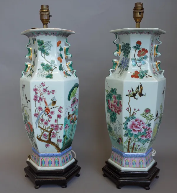 A pair of Chinese vase table lamps, early mid-20th century each painted with flora and fauna against a hexagonal baluster ground on a hardwood stand.