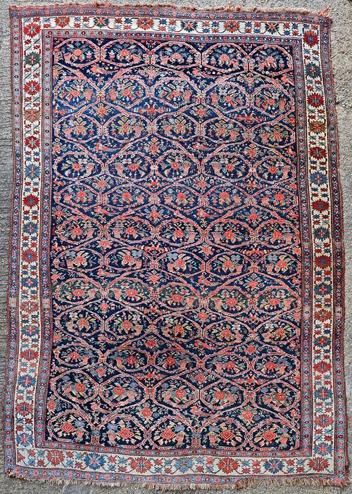 A Bidjar carpet, Persian, the dark indigo field with a trellis pattern, with each section bearing a hand holding a flower or spray of flowers; a singl