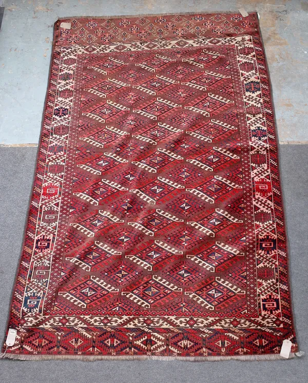 A Yomut main carpet, the brown field with an all over design of hooked diamonds; an ivory flowerhead and leaf border; leaf skirt end, 287cm x 190cm.
