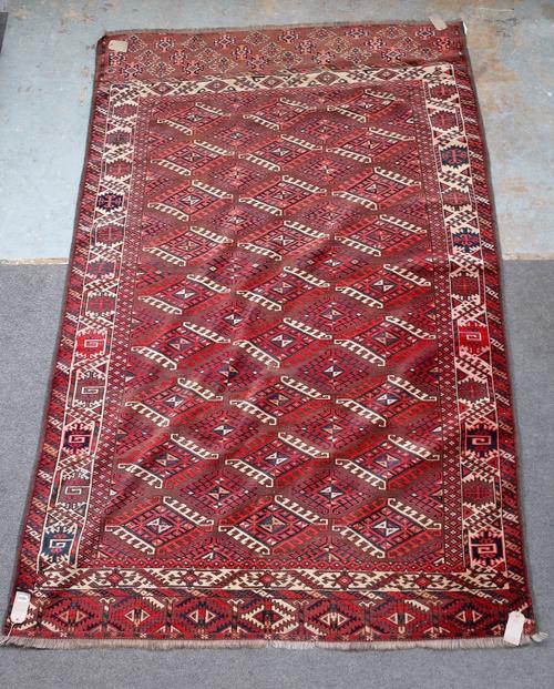 A Yomut main carpet, the brown field with an all over design of hooked diamonds; an ivory flowerhead and leaf border; leaf skirt end, 287cm x 190cm.