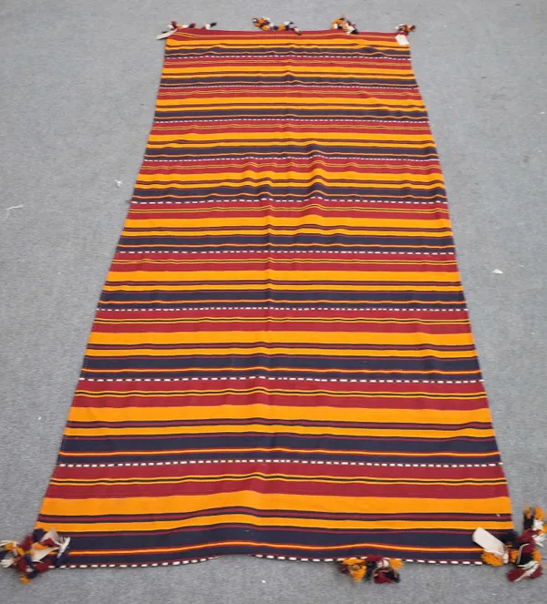 An Uzbek Gajer flateweave carpet, with banded orange madder and black bands, 330cm x 145cm.